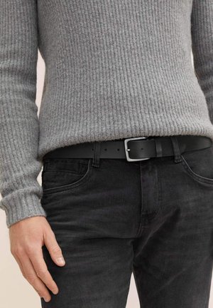Pull en maille gris à manches longues, associé à un jean noir et une ceinture en cuir noir avec une boucle carrée en argent.