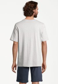 Grauer Baumwoll-T-Shirt mit kurzen Ärmeln und Rundhalsausschnitt, kombiniert mit navyblauen Shorts, die vertikale weiße Streifen haben.