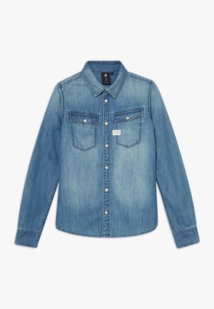 Jasnoniebieska koszula jeansowa z długim rękawem, zapinana na guziki z przodu, z dwoma kieszeniami na piersi z patkami i guzikami oraz spiczastym kołnierzem.