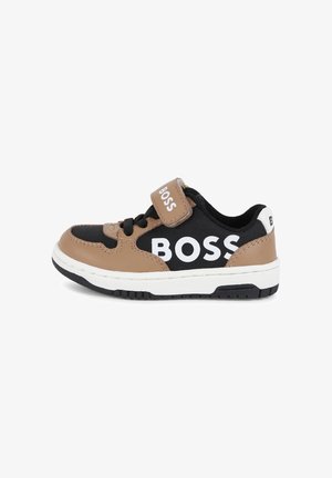 Zwarte en tan sneakers met een witte "BOSS" logo, voorzien van een klittenbandsluiting, veters, rubberen zool en contrasterende texturen tussen de materialen.