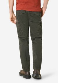 Olive green cargo pants with a tapered fit, featuring side pockets, and a smooth texture, paired with brown shoes and a red shirt.