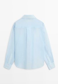 Lichtblauw overhemd met lange mouwen en knopen, met kraag, weergegeven van de achterkant tegen een witte achtergrond.