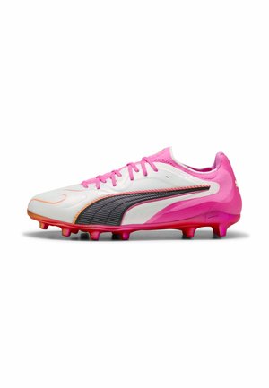 Chaussure de football blanche et rose avec bande Puma noire et orange, lacets roses et crampons moulés sur semelle rouge, vue de côté.