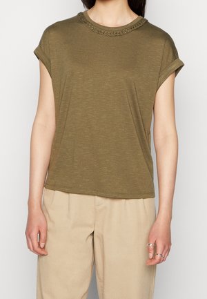 Olivgrünes T-Shirt mit kurzen Ärmeln, strukturiertem Rundhalsausschnitt und aufgerollten Ärmelabschlüssen, aus weichem Stoff gefertigt. Kombiniert mit beigen Hosen.