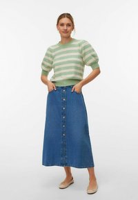 Pull rayé vert et crème en maille avec manches bouffantes, associé à une jupe maxi en denim bleu dotée d'une fermeture boutonnée à l'avant et de poches latérales.