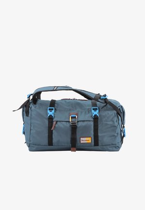 Blaues Nylon-Duffle Bag mit schwarzen Riemen, silbernen Beschlägen und einem braunen Lederakzent. Verfügt über ein Reißverschlussfach und einen Logo-Aufnäher.