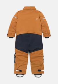 Hnedý a tmavomodrý zateplený jedno-dielny snowsuit s dlhými rukávmi, nastaviteľnými manžetami, reflexnými prúžkami a popruhmi na nohy, ležiaci na chrbte.