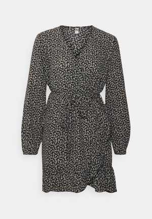 Vestido largo negro de manga larga con estampado floral blanco, cintura elástica y bajo con volantes, hasta la rodilla.