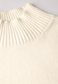 Maglione a maglia color crema con colletto alto a coste e una consistenza morbida, con un corpo liscio e dettagli di cucitura sottili.
