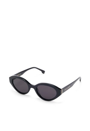 Schwarze Sonnenbrille im Katzenaugen-Stil mit dunklen Gläsern und schmalen Bügeln, liegend auf einer weißen Oberfläche.