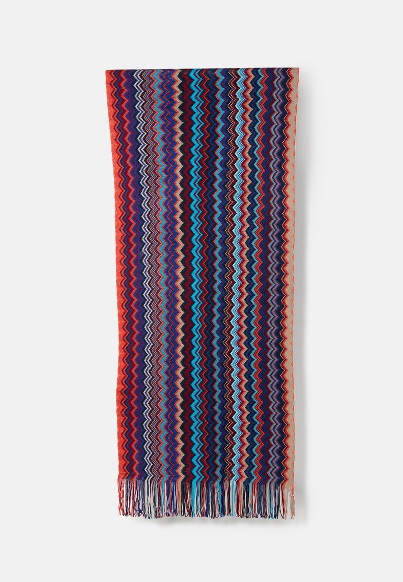 Xale tecido multicolorido com um padrão em ziguezague em azul-marinho, vermelho, turquesa e creme, rematado com longas franjas na borda inferior.