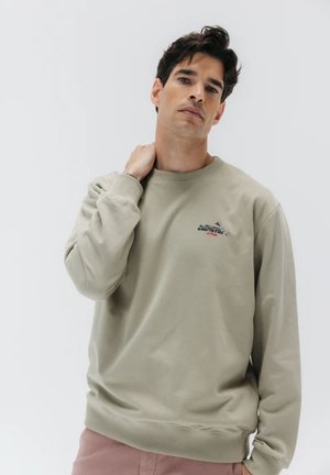 Sudadera de cuello redondo color caqui en suave algodón con mangas largas y puños de canalé. Presenta un pequeño logotipo bordado en el pecho.