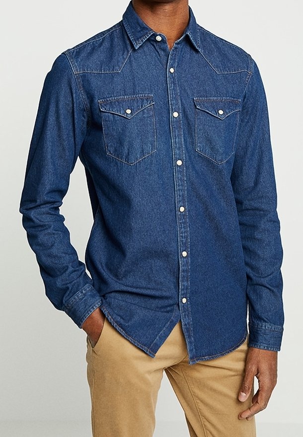 Blaue Jeanshemd mit langen Ärmeln, spitzem Kragen, zwei Brusttaschen und Knopfleiste. Verfügt über einen leicht strukturierten Stoff und einen abgerundeten Saum.