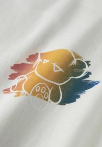 Tissu blanc avec un fond multicolore en coups de pinceau et une illustration centrée d'un ours en peluche contour blanc.