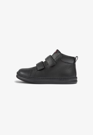 Black leather ankle boot with two Velcro straps, rounded toe, rubber sole, and subtle stitching details. Smooth texture with a pull tab.