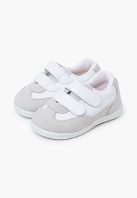 Grijze en witte sneakers van een suède-achtig materiaal, met een ronde neus en dubbele klittenbandsluitingen. Witte meshvoering en een flexibele rubberen zool.