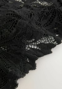 Țesătură din dantelă neagră cu modele florale elaborate, margini ondulate și texturi variate; aspect ușor și semi-transparent.