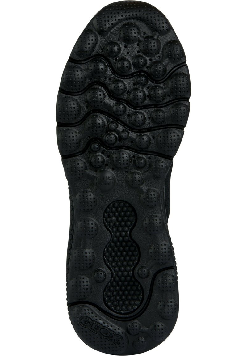 Semelle de chaussure en caoutchouc noir présentant un motif texturé avec plusieurs formes circulaires et ovales, des rainures et des trous de ventilation pour la respirabilité.