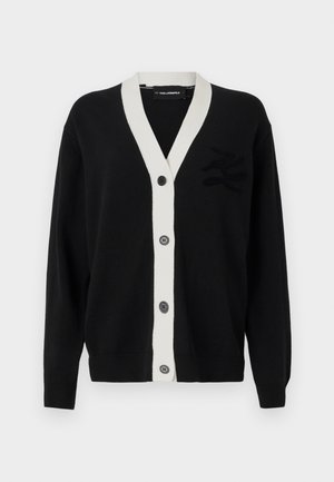 Black cardigan with white V-neck trim and five front buttons. Features a textured logo on the left side. Made of soft material.