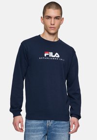 Felpa blu navy in cotone, con scollo rotondo, maniche lunghe e logo ricamato "FILA" con accenti rossi e bianchi.