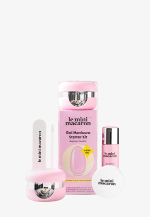 Kit de inicio para manicura con gel rosa Mini Macaron con lámpara LED, esmalte de gel, lima de uñas y accesorios para el cuidado de las uñas sobre fondo blanco.