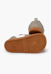 Scarpe per bambini grigie e bianche con suola in gomma testurizzata, caratterizzate da punta rotonda, linguetta posteriore e etichetta del marchio sulla suola.