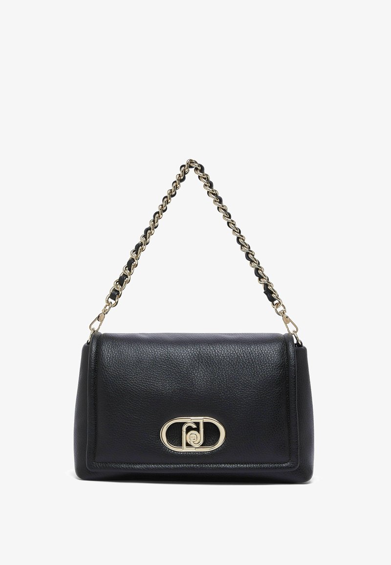 Sac à main en cuir noir avec bandoulière chaîne dorée et fermoir ovale doré à l'avant, sur fond blanc uni.