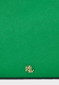 Žalia tekstūruota odinė rankinė su auksiniu „RL“ logotipu apatiniame kampe. Strukturizuotas dizainas su lygiu paviršiumi ir minimalia aparatūra.