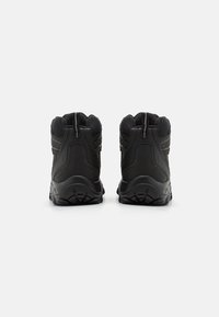 Bottes de randonnée noires avec une tige texturée, un col rembourré et une semelle en caoutchouc. Présente un talon renforcé et des détails de couture subtils.