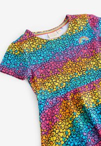 Kleid mit kurzen Ärmeln, das ein Regenbogen-Blumenmuster in lebhaften Farben zeigt: Pink, Lila, Blau, Orange und Gelb. Weicher Stoff, runder Ausschnitt.
