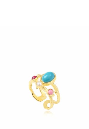 Bague en or avec une bande irrégulière présentant quatre pierres : un grand turquoise, un petit rouge, un rose et une perle blanche, sur fond blanc.