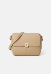 Beige skinncrossbody-veske med et flatt topplokk, gullmetallkomponenter, strukturert form og subtile sømdetaljer på forsiden.