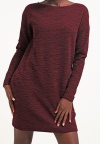Abito in maglia color bordeaux con un motivo a strisce testurizzate; presenta un collo a barca e maniche lunghe, offrendo una vestibilità ampia e rilassata.