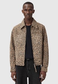 Μπουφάν με σχέδιο λεοπάρ, γιακά, φερμουάρ μπροστά και δύο τσέπες στο στήθος. Φτιαγμένο από απαλό ύφασμα, με αποχρώσεις καφέ και μαύρου.