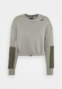 Zkrácená šedá mikina s dlouhými rukávy, zelenými akcentními panely, elastickými manžetami a logem Nike na hrudi. Měkký bavlněný materiál.