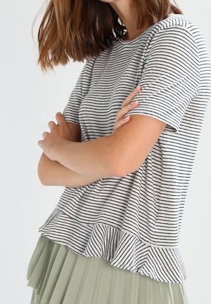 Top de manga corta a rayas en algodón gris y blanco, con un dobladillo con volantes. Combinado con una falda plisada de color verde claro.