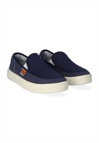 Marineblauwe instap schoenen met een textiele bovenkant, contrasterende witte rubberen zool en een klein logo detail op de zijkant.