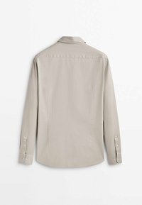 Jasnoszara koszula z długim rękawem, zaostrzonym kołnierzem, mankietami na guziki i karczkiem z tyłu. Gładka tkanina z subtelnym połyskiem.