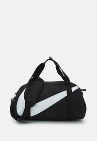 Black duffel bag made of durable fabric featuring a large white Nike swoosh, adjustable shoulder strap, and twin carry handles.