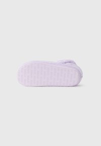 Fialový papuč s jemnou, huňatou textúrou; má vzorovanú gumovú podrážku s vyrazeným nápisom "crocs"; zaoblená špička a bočné detaily.