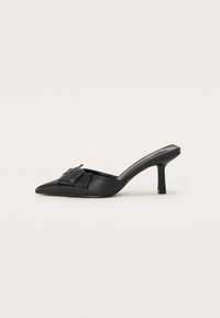 Mules à talons en cuir noir avec un pointu et un accent de nœud décoratif à l'avant, présentant un talon slim de forme carrée.