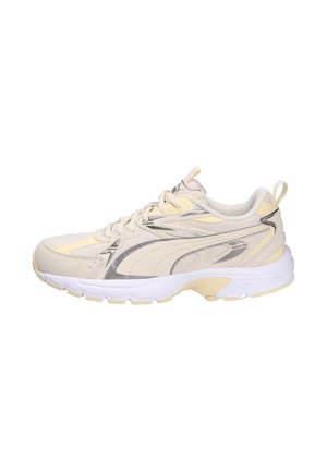 Lichtbeige atletische schoen met een textuur bovenkant, zilveren accenten en een witte tussenzool. Beschikt over veters en een aantreklipje op de hiel.