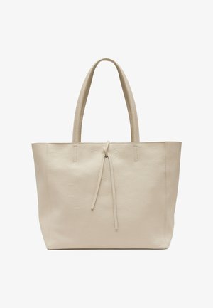 Grand sac cabas en cuir beige avec deux anses et une fermeture simple par lien à l'avant, surface texturée, posé debout sur fond blanc.
