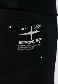 Zwarte sweatshirt met een geribbelde halslijn, witte grafische print en logodetails aan de voorkant. De stof lijkt zacht en glad te zijn.