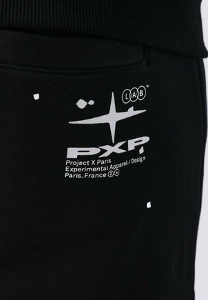 Zwarte sweatshirt met een geribbelde halslijn, witte grafische print en logodetails aan de voorkant. De stof lijkt zacht en glad te zijn.