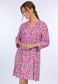 Pink floral dress with a V-neck, 3/4 sleeves, and an A-line silhouette. Features a small floral pattern throughout the fabric.
