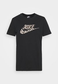 Svart bomulls t-shirt med en leopardmönstrad Nike-logotyp över bröstet. Klassisk rund halsringning och korta ärmar.