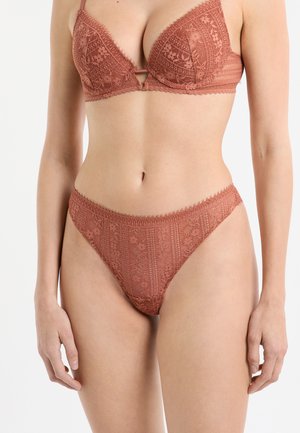 Soutien-gorge en dentelle et string assorti de couleur terre cuite douce. Présente des motifs floraux délicats, des bords festonnés et des bretelles réglables.
