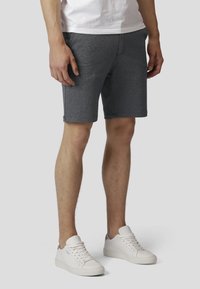 Grå, teksturerte shorts med skreddersydd passform, med flat midje og sidelommer, kombinert med hvite sneakers.
