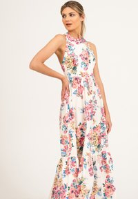 Kwiatowa sukienka maxi z wysokim dekoltem i bez rękawów. Posiada biały fason z kolorowymi różami oraz warstwowym dołem.